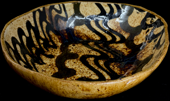 a slab built bowl with slip trailed design inside.